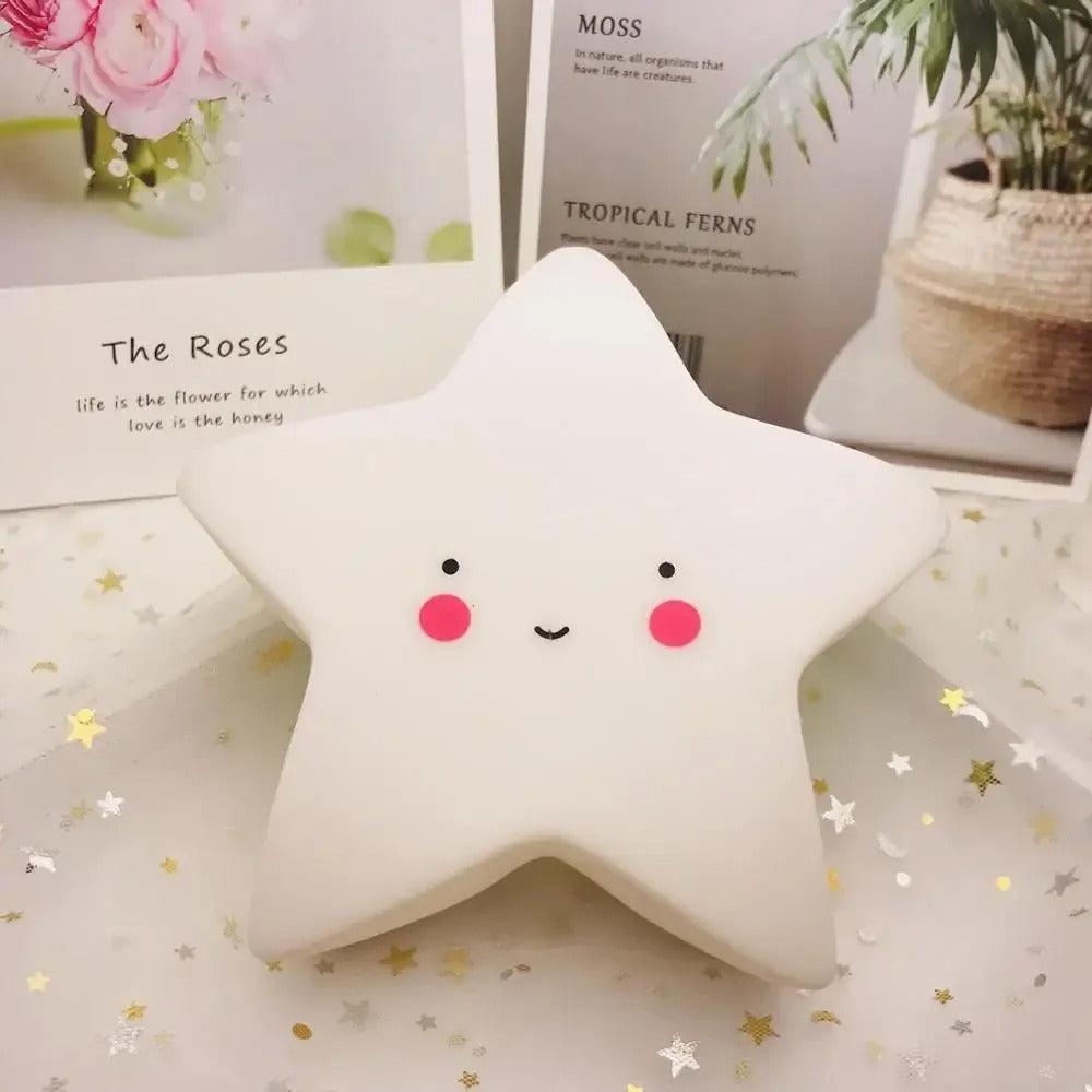 BEBE VEILLEUSE - StarNight™ blanche posée sur une surface blanche avec des petites étoiles dorées