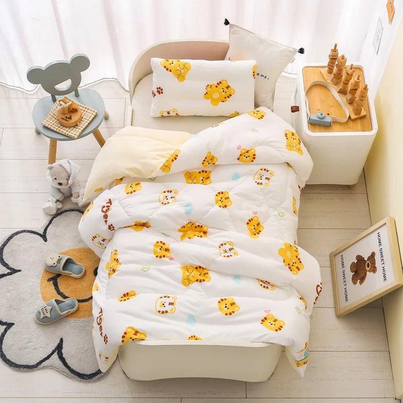 UNE CHAMBRE D'ENFANT AVEC UN LIT SUR LEQUEL EST POSEE COUETTE POUR BEBE HYPOALLERGENIQUE – NuageDouillet™ AVEC DES MOTIFS TIGRE