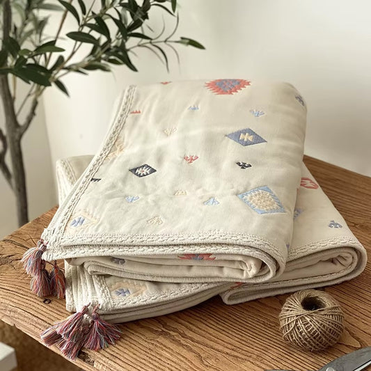 Gros plan sur la COUVERTURE_BEBE_EN_COTON_BIOLOGIQUE_NaturaDouce_-_Indien_magique posée sue un meuble