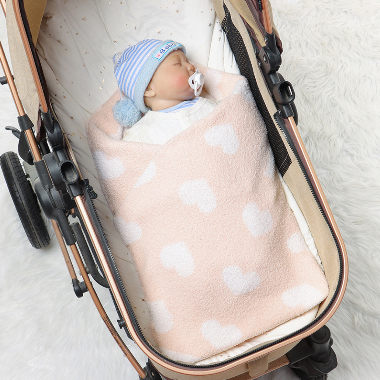 Bebe dort dans sa poussette emmailloté dans une COUVERTURE BEBE POLAIRE │ Sérénaya™ couleur rose