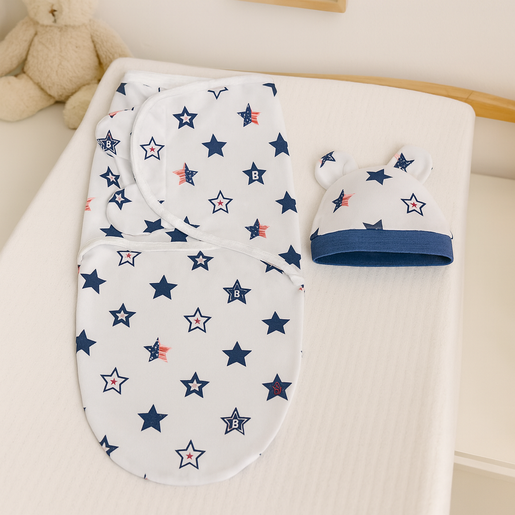 Ensemble de couverture emmaillotage bébé et bonnet assorti motif étoiles bleu marine et rouge, posé sur une table à langer dans une chambre douce et apaisante.