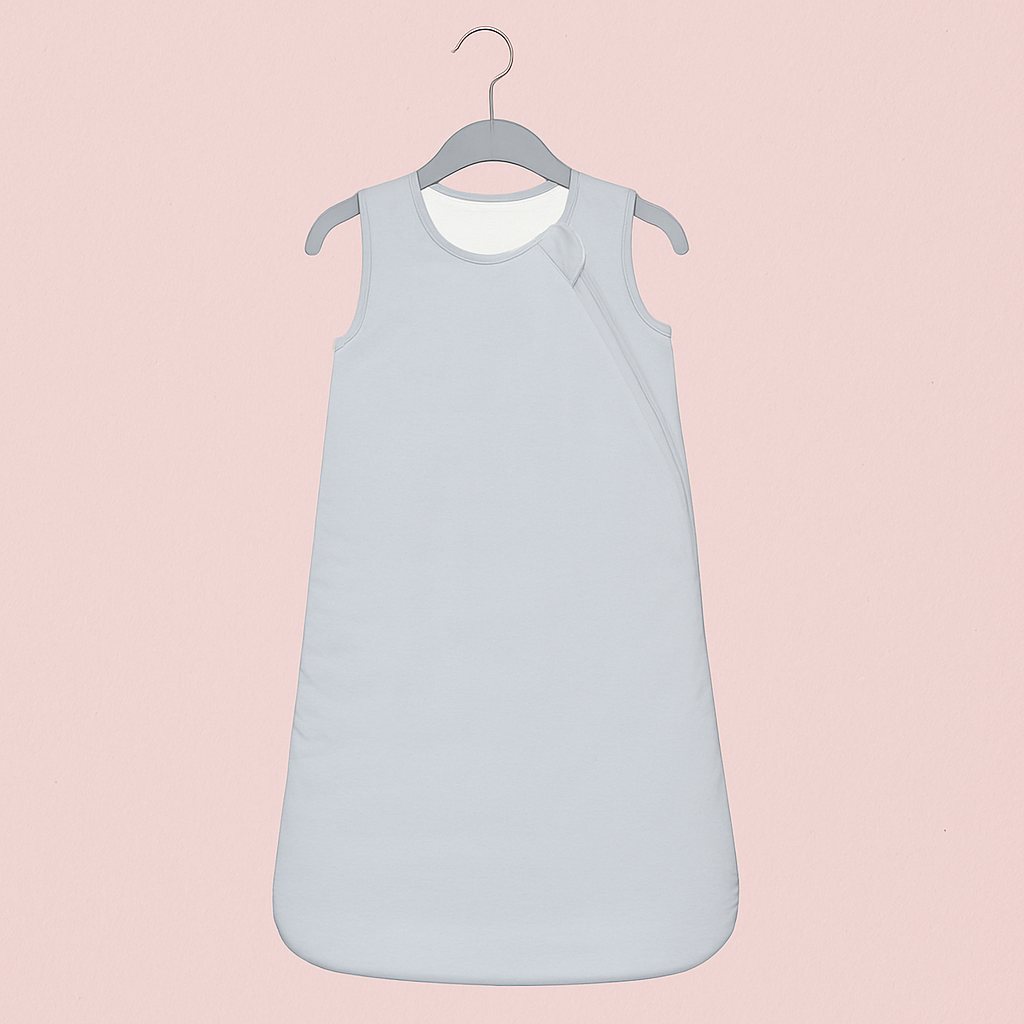 Gigoteuse Printemps et Automne gris clair accrochée à un cintre gris, sur fond rose poudré élégant, style épuré et moderne.