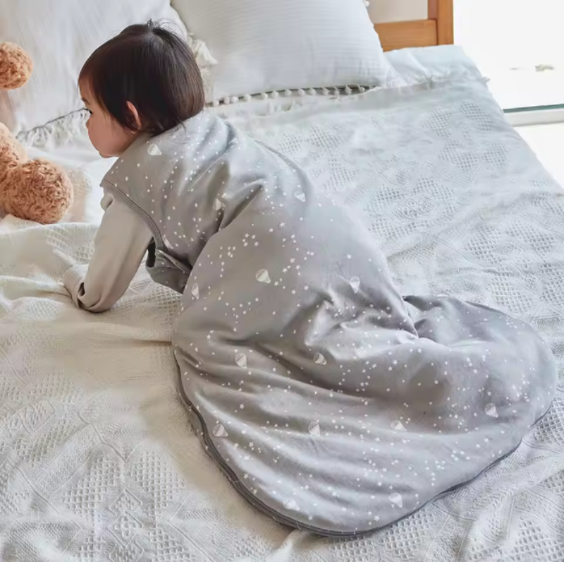 Un bébé vétu de la Gigoteuse turbulette│RoyaumeDesRêves - Ballon est à quatre pattes sur le lit de ses parents