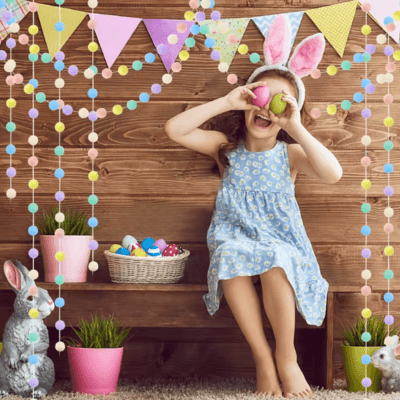 Une petite fille assise sur un banc et au dessus de sa tête des Guirlande chambre de bébé│Boréa™