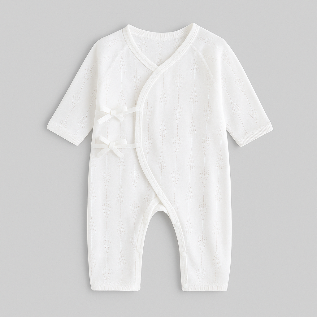 Pyjama bebe en coton blanc uni mi-saison avec petits nœuds latéraux et tissu respirant, conçu pour le confort et le sommeil serein des nouveau-nés.