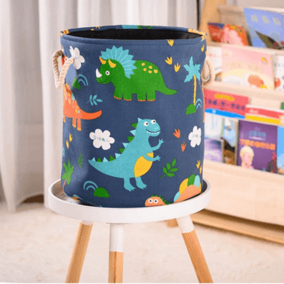 Panier de Rangement pour Bébé - Terre des Dinos™posé sur une table basse ronde devant devant un porte magazines et des rideaux