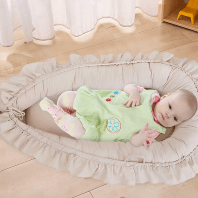 Bébé allongé dans le REDUCTEUR DE LIT BEIGE - Rêve de Lin™