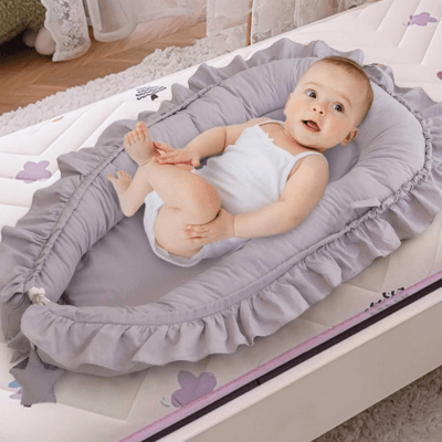 Bébé paisible dans le REDUCTEUR DE LIT GRIS - Rêve de Perle™.