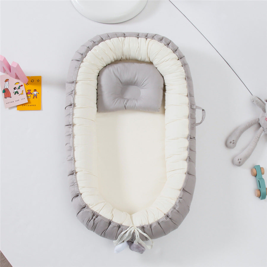REDUCTEUR DE LIT POUR BEBE 100% COTON Sodalite™ gris uni, vu du dessus, dans une ambiance douce et épurée.