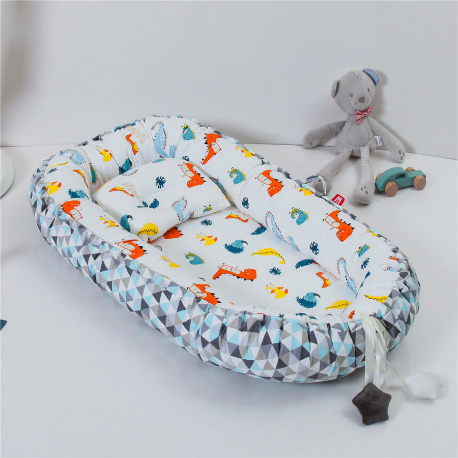 REDUCTEUR DE LIT POUR BEBE 100% COTON Sodalite™ avec motif dinosaures colorés et contour géométrique, dans une chambre d’enfant lumineuse.
