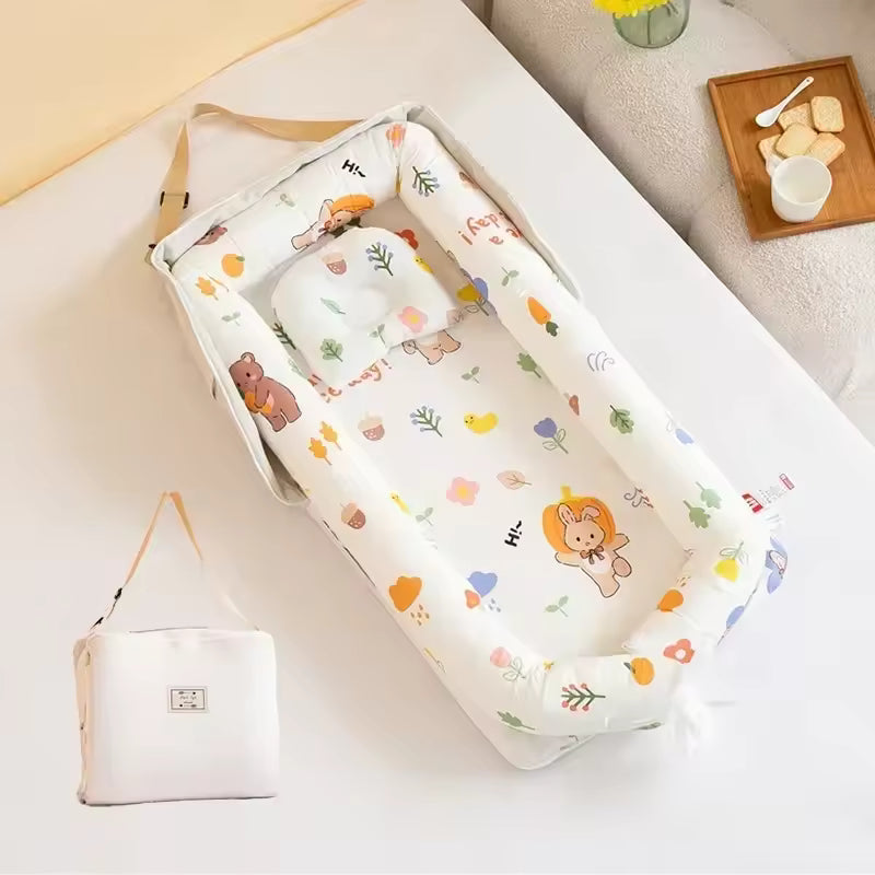 Réducteur de lit beige pour bébé motifs animaux vu de dessus, avec son coussin assorti et son sac de transport posé à côté sur un lit lumineux.