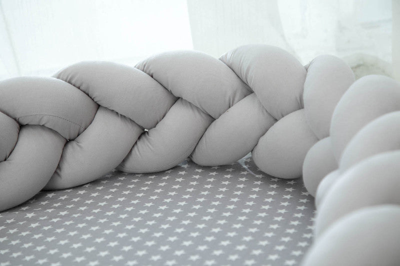 Zoom sur le Réducteur de Lit Tressé│Nattou™ gris avec matelas à motifs étoiles, soulignant la douceur et la sécurité du cocon pour bébé.