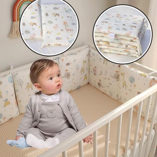 Tour de Lit Bébé Animaux-JolieForêt™ installé dans un berceau blanc, motifs animaux pastel et forêt un bébé assis dans le berceau et des bulles montrent les attaches des coussins