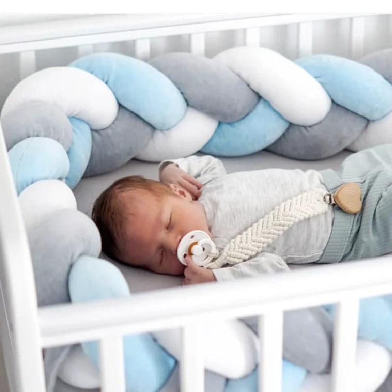 Un bébé qui dort dans un berceau blanc autour d'une Tresse de lit bébé Bleu gris blanc