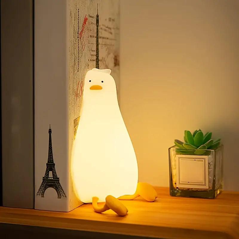 VEILLEUSE BEBE CANARD - MonsieurCoinCoin™ posée sur une étagère en guise de serre livre