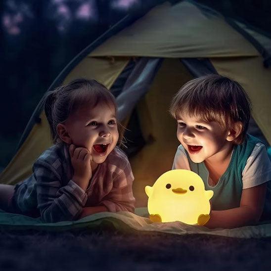 Une petite fille et un petit garçon son sous une tente éclatée par une VEILLEUSE BEBE CANETON