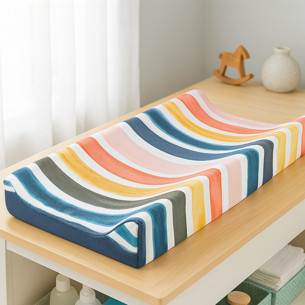 Housse matelas à langer imperméable RainbowWave™ LeafyCare™, installée sur une table à langer dans une chambre bébé lumineuse.