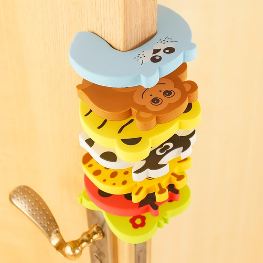 Lot coloré de bloque porte bébé en mousse EVA sur porte en bois clair, designs animaux ludiques pour sécuriser la maison avec style.