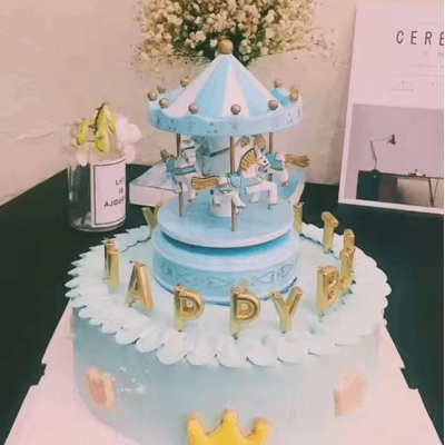 Boite à Musique Bébé - bleue posée sur un gateau d'anniversaire 