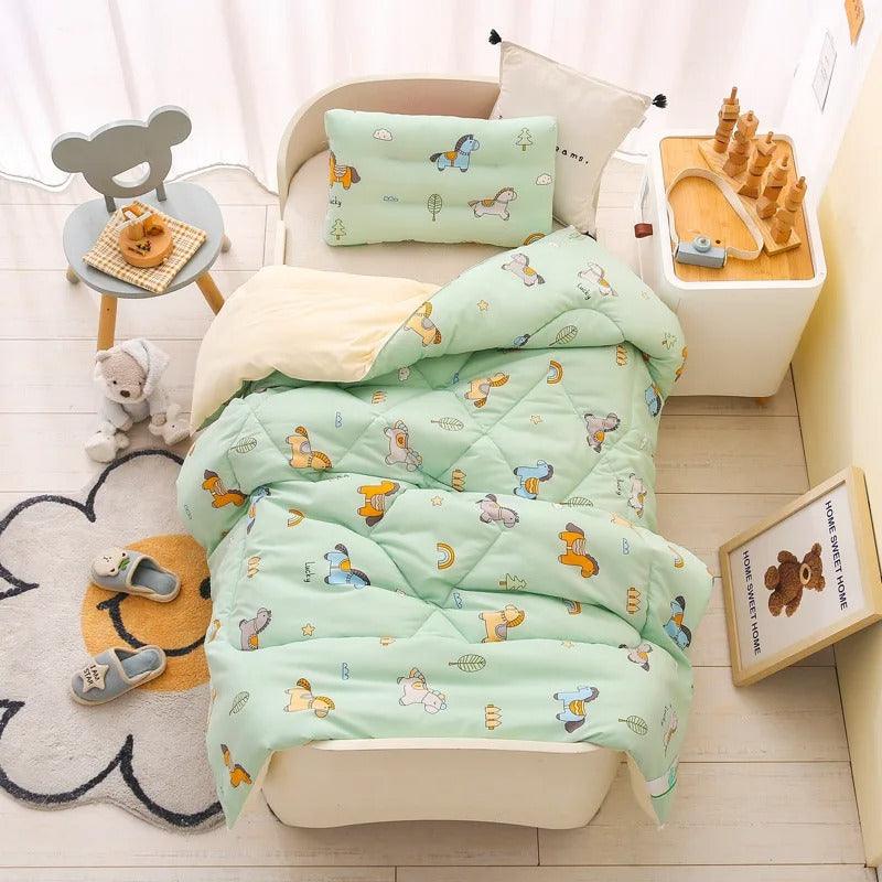UNE CHAMBRE D'ENFANT AVEC UN LIT SUR LEQUEL EST POSEE UNE COUETTE POUR BEBE HYPOALLERGENIQUE – NuageDouillet™ AVEC DES  MOTIFS LICORNES