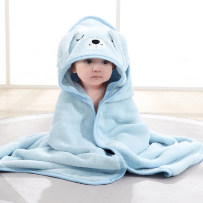 Un bebe porte le Cape de Bain Bébé à Capuche - Douceur Câline™ bleue-Chien avec la capuce sur la tête 