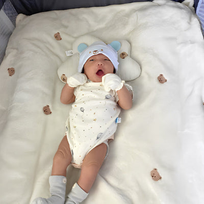Bébé dans un berceau, sur une Couverture Bébé Tête d'Ourson│DouDodo™