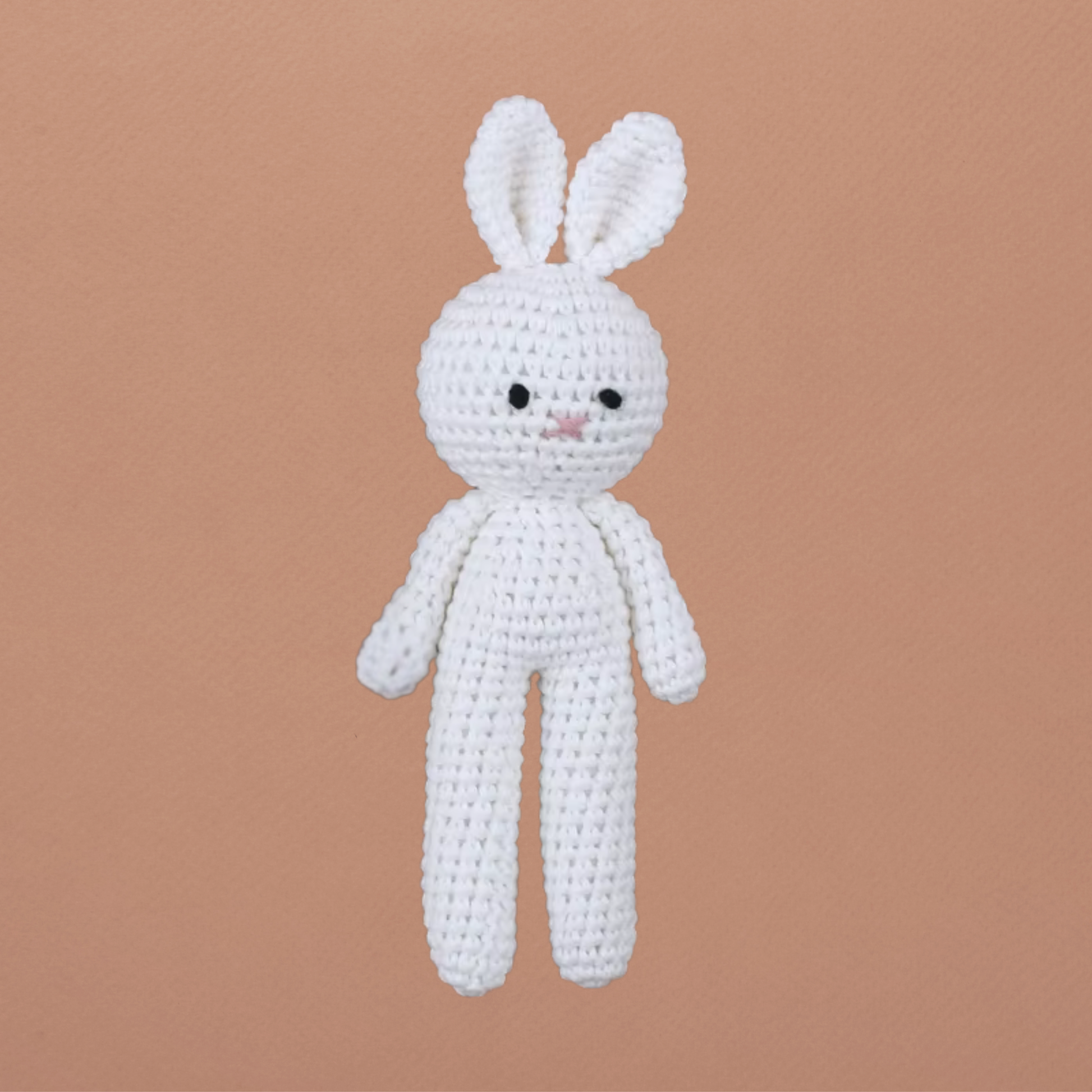 Grand doudou lapin blanc Calimail™ 19 cm, en maille crochetée sur fond terracotta clair.