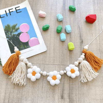 Guirlande pompons chambre bébé│Bohonia sur une table avec des morceaux de craie de toules les couleurs