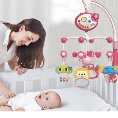 Une maman se penche sur son bébé dans son berceau. Il regardent tous les deux le Mobile Bébé Musical et Lumineux -  StellaTune™fixé au dessus du berceau