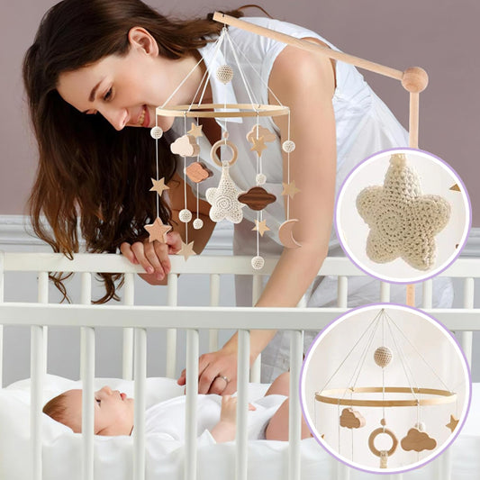 Mobile bébé BabyAwake™ en bois naturel suspendu au-dessus d’un berceau et maman penchée parle à son bébé