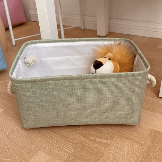 Panier de Rangement Pour Bébé - Vert posée au sol avec une peluche ours dedans