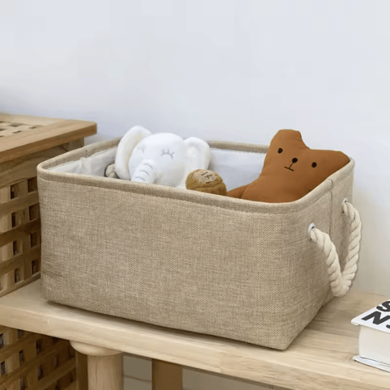 Panier de Rangement Pour Bébé - Beige posée sur une table avec dedans un éléphant et un ours en tissu 