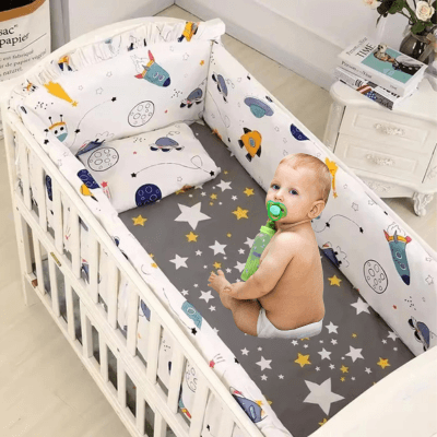 Une Parure de Lit Enfant - CoconPur en coton biologique dans un berceau avec un petit garço assis une tétine à la bouche