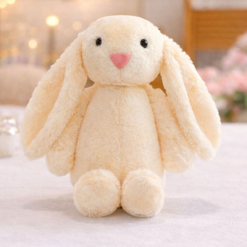 Peluche lapin pour bébé beige aux longues oreilles posée sur une surface douce