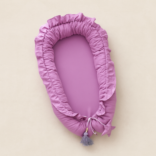 Réducteur de lit bebe mauve BabyLilas™ sur fond beige, cocon élégant et sécurisant pour un sommeil paisible.