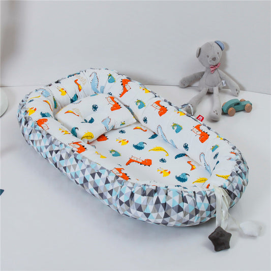 REDUCTEUR DE LIT POUR BEBE 100% COTON Sodalite™ avec motif dinosaures colorés et contour géométrique, dans une chambre d’enfant lumineuse.