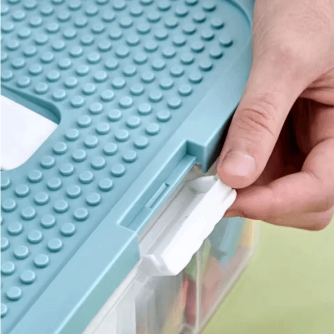 Ouverture facile en un clic avec le pouce sur la petite poignée sur le coté du Rangement jouet enfant - TidyBox™