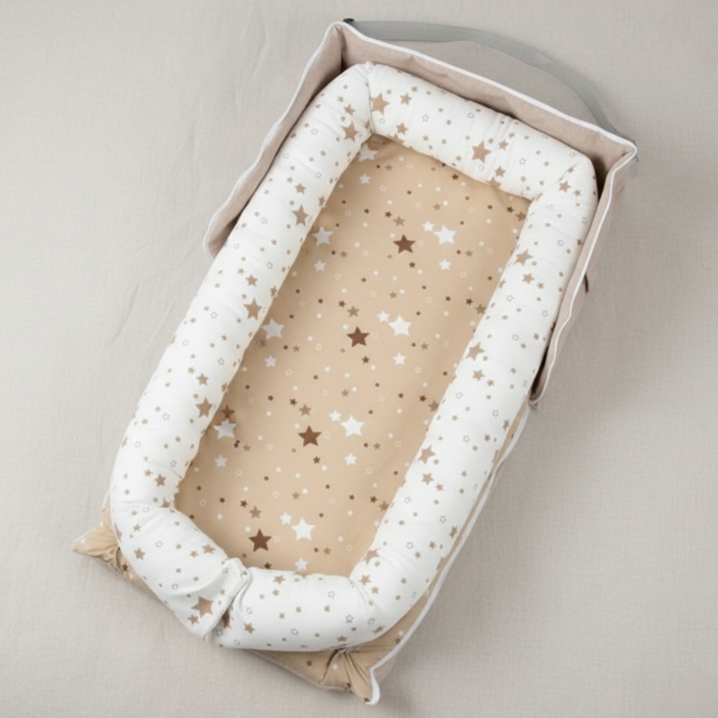 Réducteur de lit bébé StarrySky™ beige avec matelas étoilé vu de dessus, pour un confort 360°.