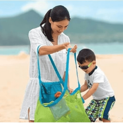 Un garçon à la plage avec sa maman range ses jouets dans le Sac de Rangement jouets - CarryTidy™