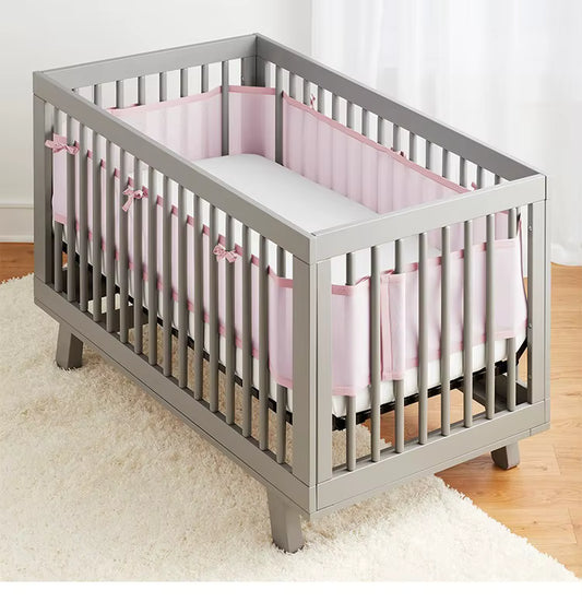 Tour de lit bébé rose PinkyMesh™ installé dans un berceau blanc scandinave, design élégant et respirant, créant une chambre douce et sécurisée.