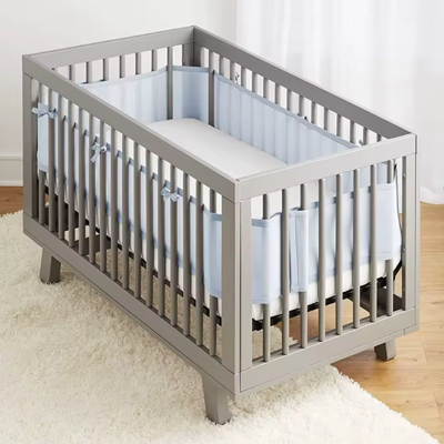 Tour de lit respirant bleu MeshiBlue™ installé dans un berceau blanc, tissu mesh 3D bleu offrant protection et circulation d’air optimale pour bébé.