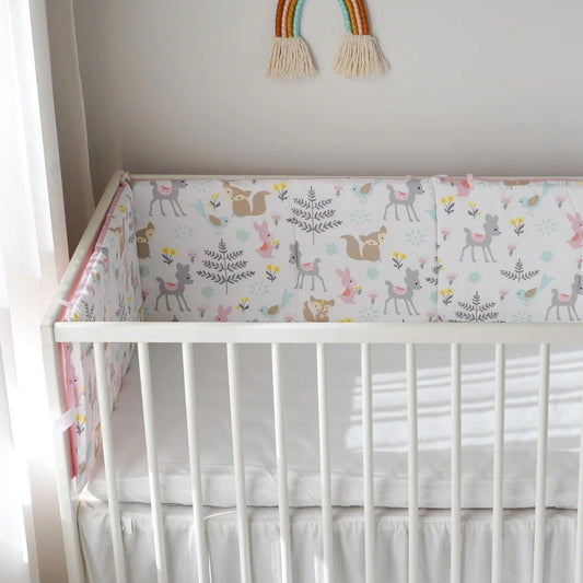 Tour de lit bébé feuillage disposé en L autour d'un berceau blanc 