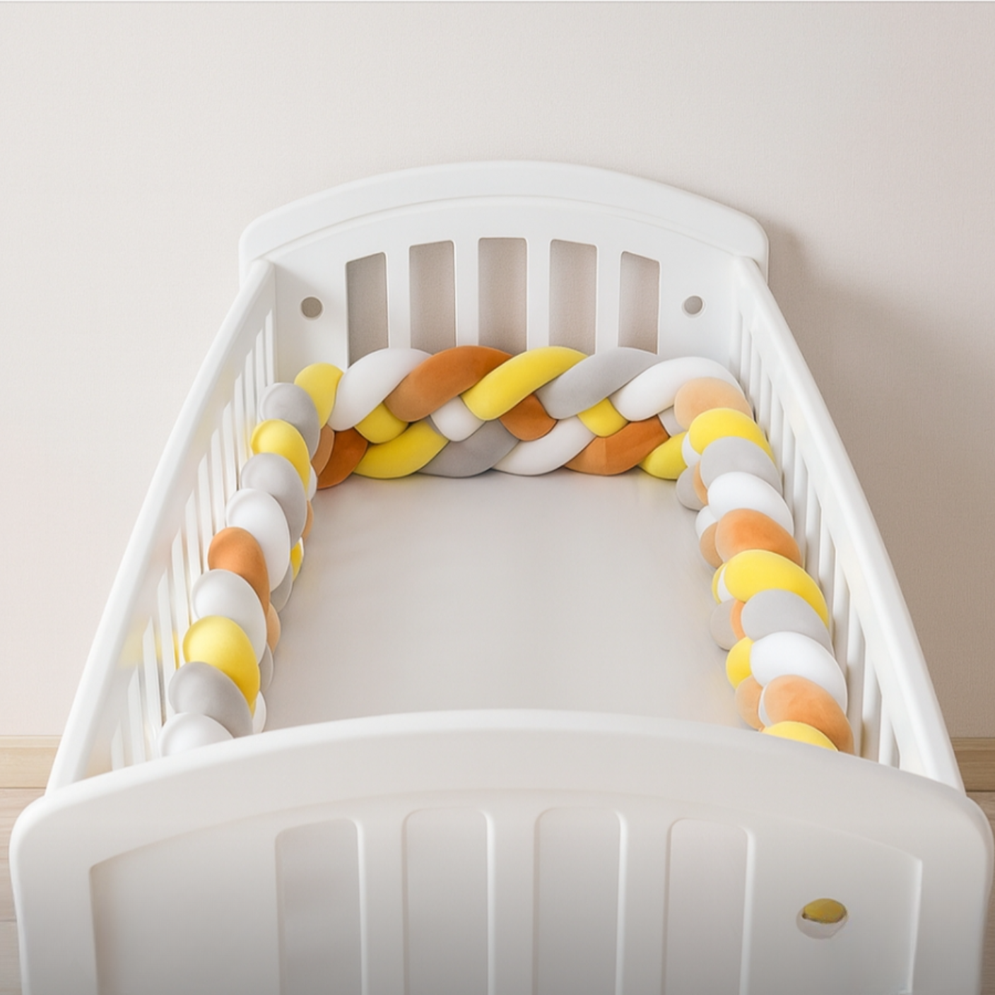 Tresse_de_lit_bebe_4_brins_jaune_blanc_gris_et_marron_LineaDouce_installee_dans_un_berceau_blanc_dans_une_chambre_scandinave_lumineuse_au_mur_beige_clair_ambiance_douce_et_apaisante