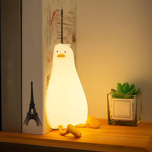 VEILLEUSE BEBE CANARD - MonsieurCoinCoin™ posée sur une étagère en guise de serre livre