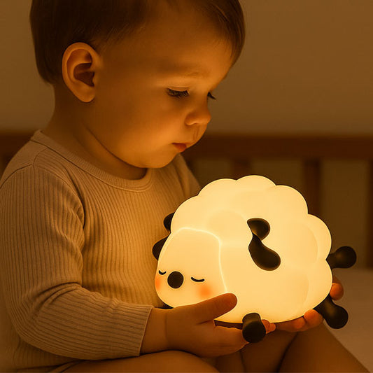 Bébé en pyjama tenant une veilleuse mouton allumée dans ses bras – lumière douce pour rassurer bébé la nuit