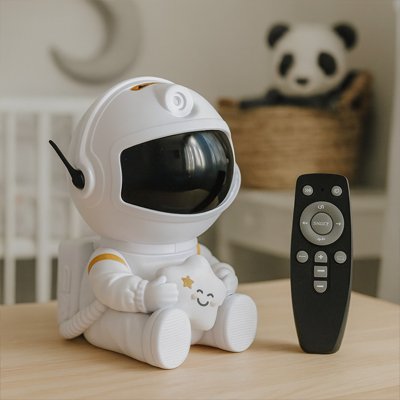 Veilleuse Projection Ciel Étoilé UniversMagique™ posée sur un meuble à côté de sa télécommande, dans une chambre de bébé douce et épurée avec un berceau blanc et un panier en osier contenant une peluche panda.