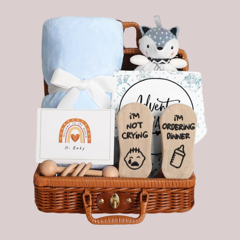 Coffret naissance bebe bleu WelcomeBaby avec couverture douce, doudou renard et accessoires en bois dans une valisette en osier.