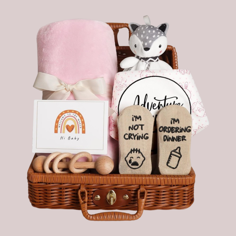 Coffret naissance bebe rose WelcomeBaby avec couverture rose poudré, doudou renard, chaussettes humoristiques et accessoires en bois.
