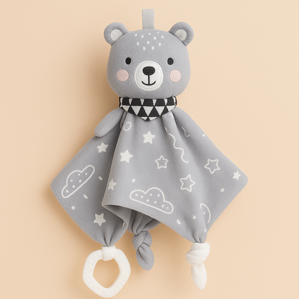 Doudou bébé Toloman modèle ours, présenté sur un fond beige rosé doux, avec anneau de dentition et motifs étoilés