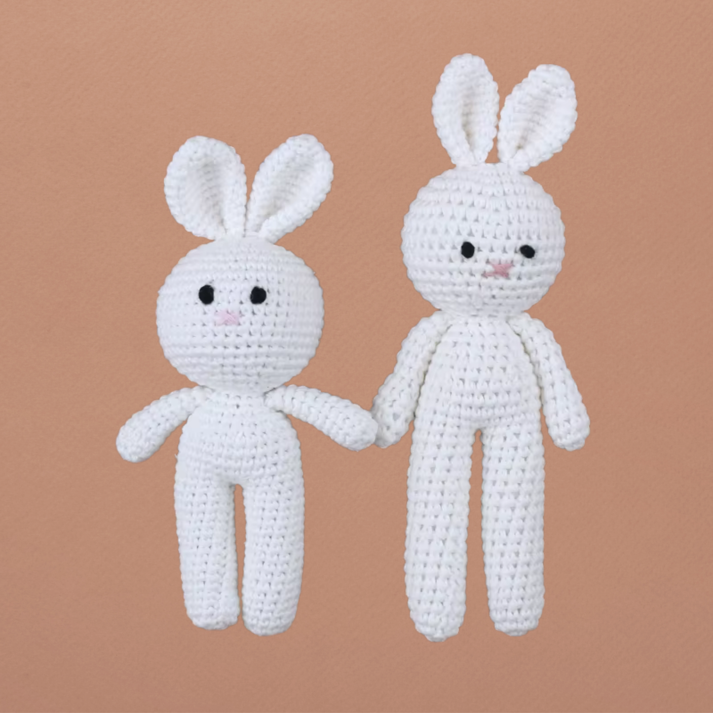 Doudou lapin blanc Calimail™ en deux tailles, 15 cm et 19 cm, sur fond terracotta clair.